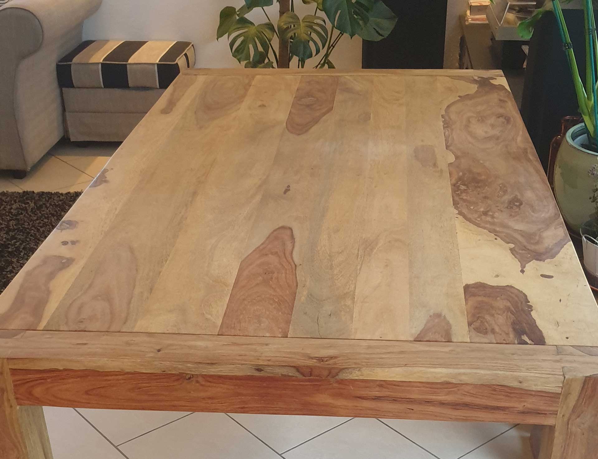Auf dem Bild sieht man einen ausgeblichenen, ausgetrockneten und spröden Esstisch aus Holz