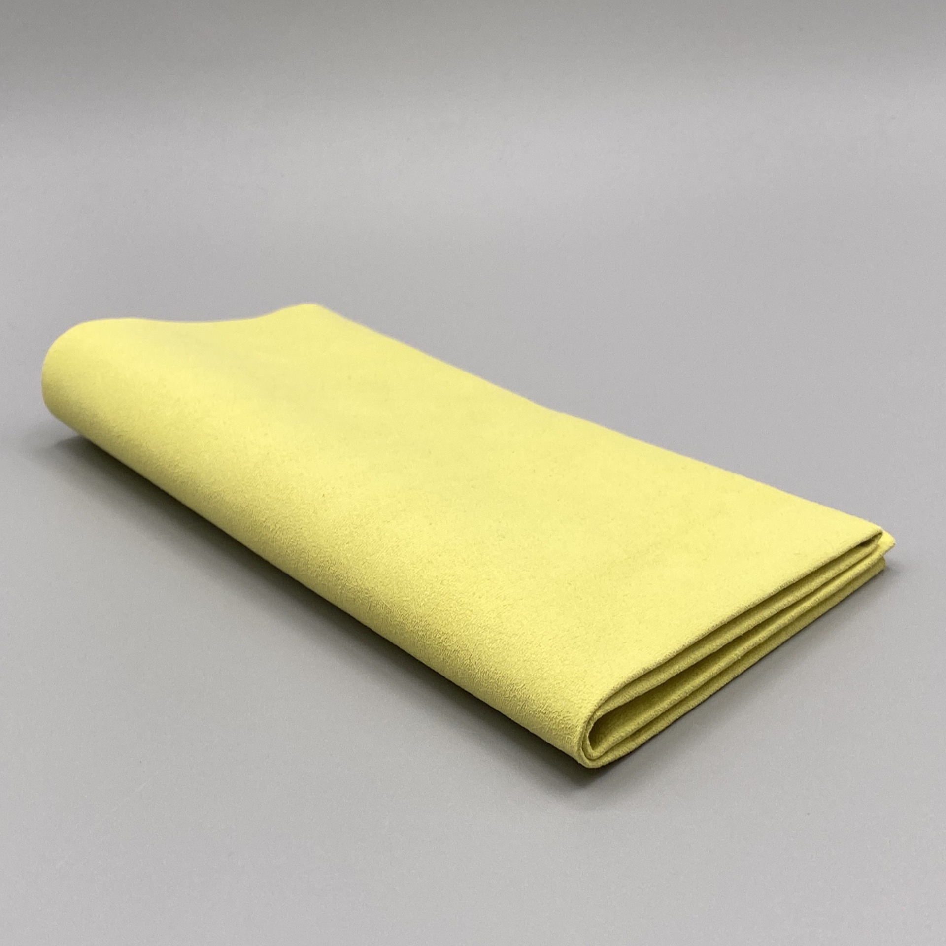 Ein zweifach gefaltetes, gelbes Microfasertuch in Premium-Qualität 